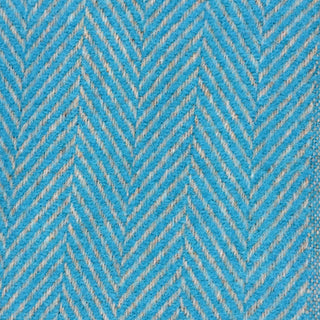 Close-up texture detail of a sky blue herringbone recycled wool blanket showing the woven herringbone pattern and soft wool fibers