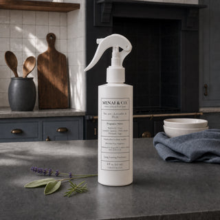 Lavender and Herb linen and room spray styled in a kitchen with lavender, rosemary, and sage.