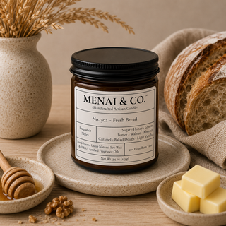 Fresh Bread soy candle in amber glass jar styled with artisan bread, honey dipper, butter, walnuts, and warm neutral kitchen decor