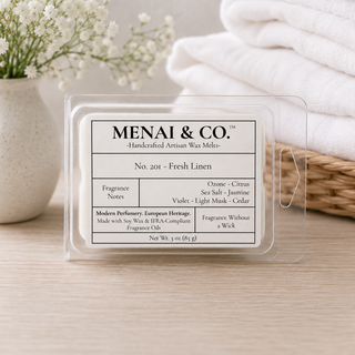 Fresh Linen soy wax melts in six-cavity clamshell beside folded white linens and soft white florals