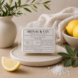 Lemon Leaf and Sea Salt soy wax melts in six-cavity clamshell styled with fresh lemons, sea salt crystals, olive branches, and soft neutral linens